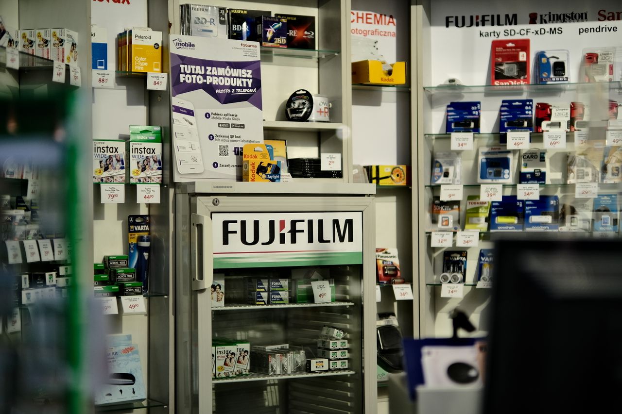 Interior view of a camera store showcasing a variety of photography products including Fujifilm items.